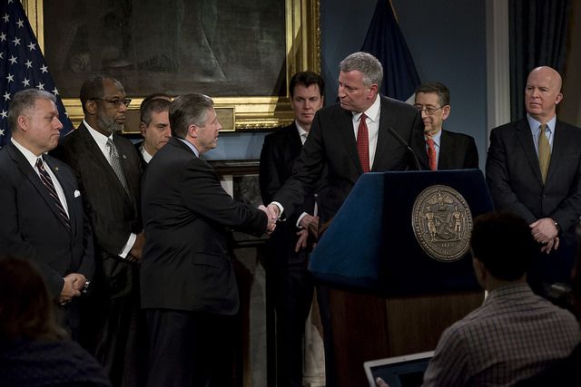 Mayor Bill de Blasio shakes hands with Patrolmen's Benevolent Association president Pat Lynch at a press conference announcing a proposed contract for rank-and-file NYPD officers.